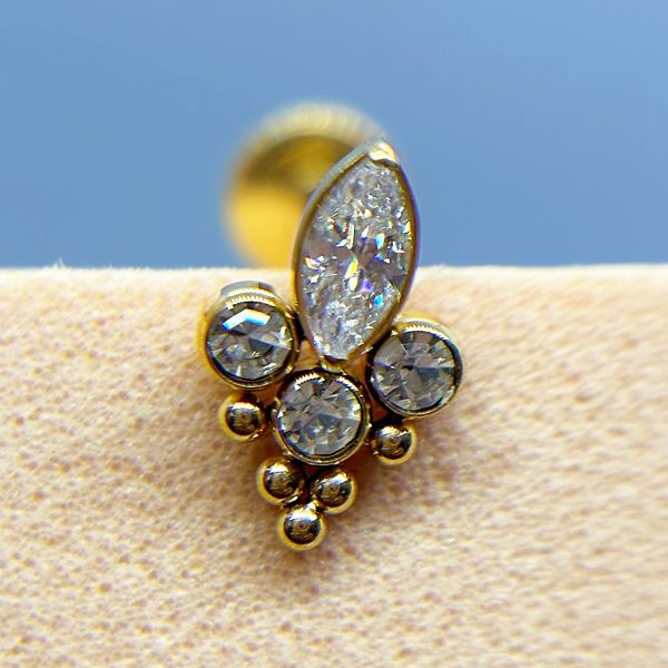 Close-up of a gold and crystal earring on a display stand