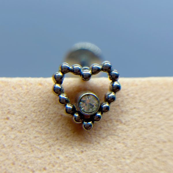 Heart-shaped beaded stud earring with a clear central gem on skin