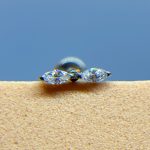 Close-up of a diamond stud earring with a silver backing against a blue background
