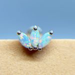 Three opal marquise stones set in a silver stud earring against a blue background