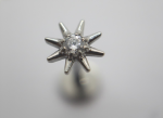 Close-up of an eight-pointed silver star stud with a small central clear gemstone against a soft gray blurred background